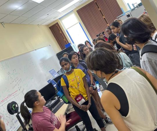 Picture of engineering student Natalie Liang taking a group of middle school students on a tour of engineering research labs